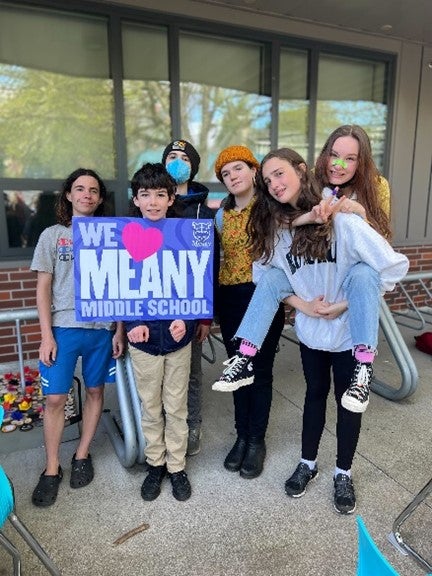 Meany Middle Schools students holding a sign that says we love meany